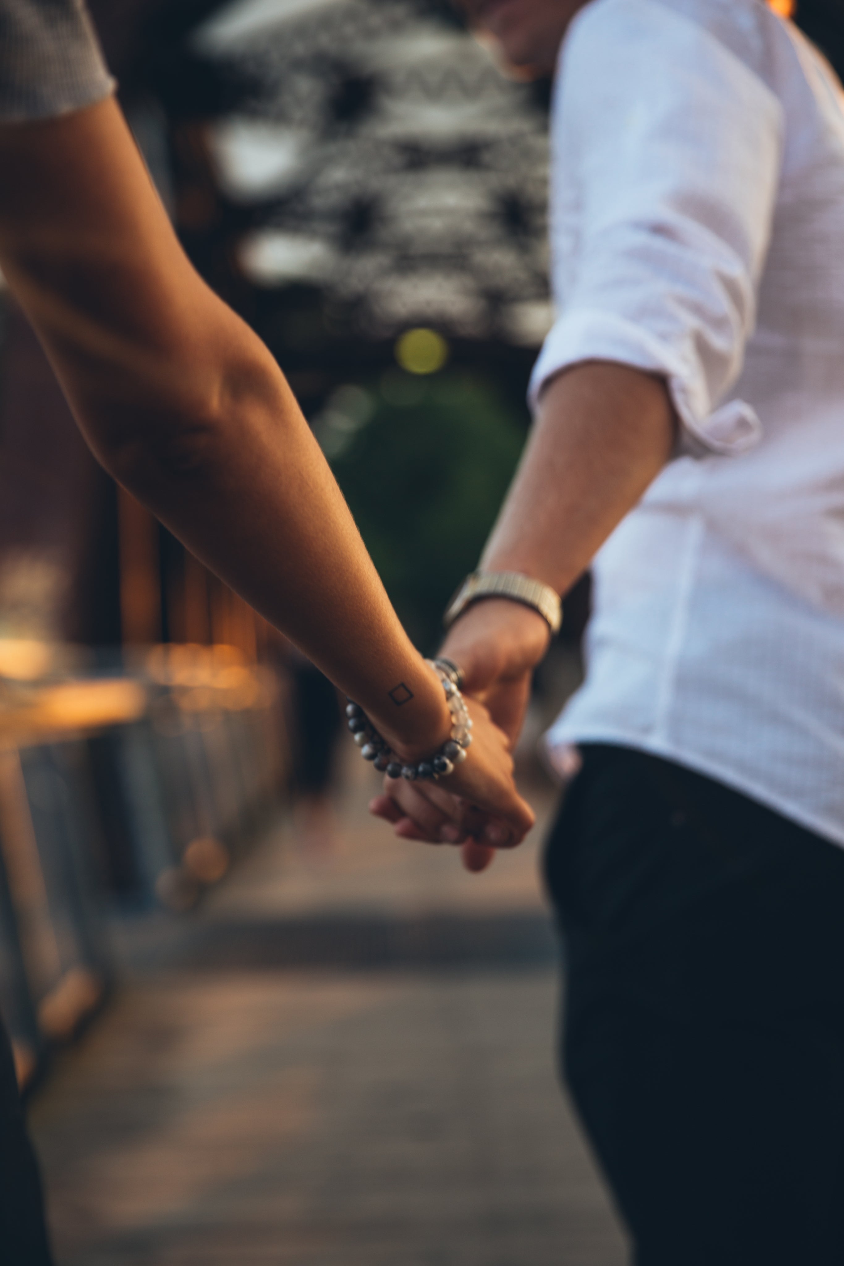 A couple walking on a bridge holding hands
